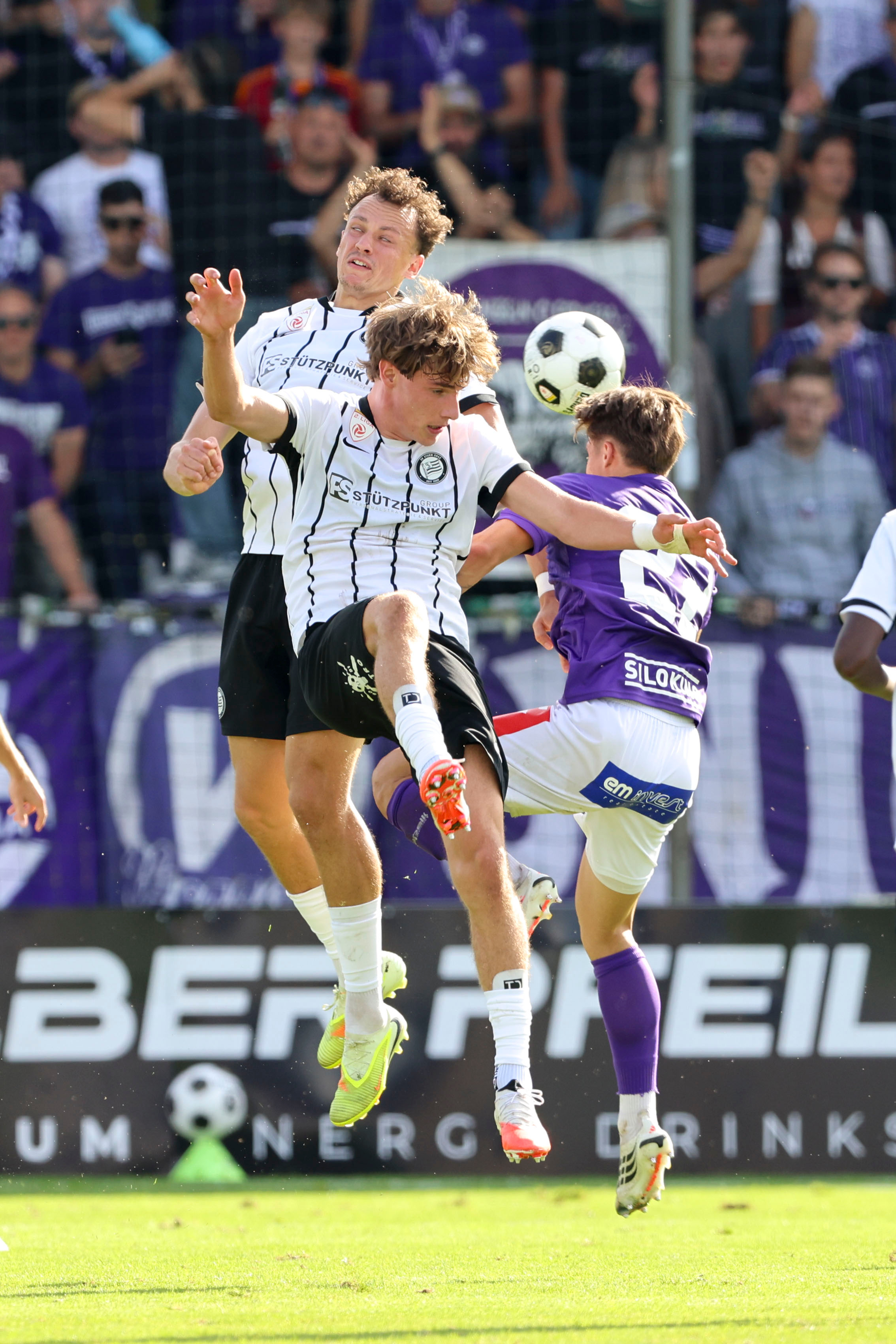 Kopfballduell dreier Fußballer.