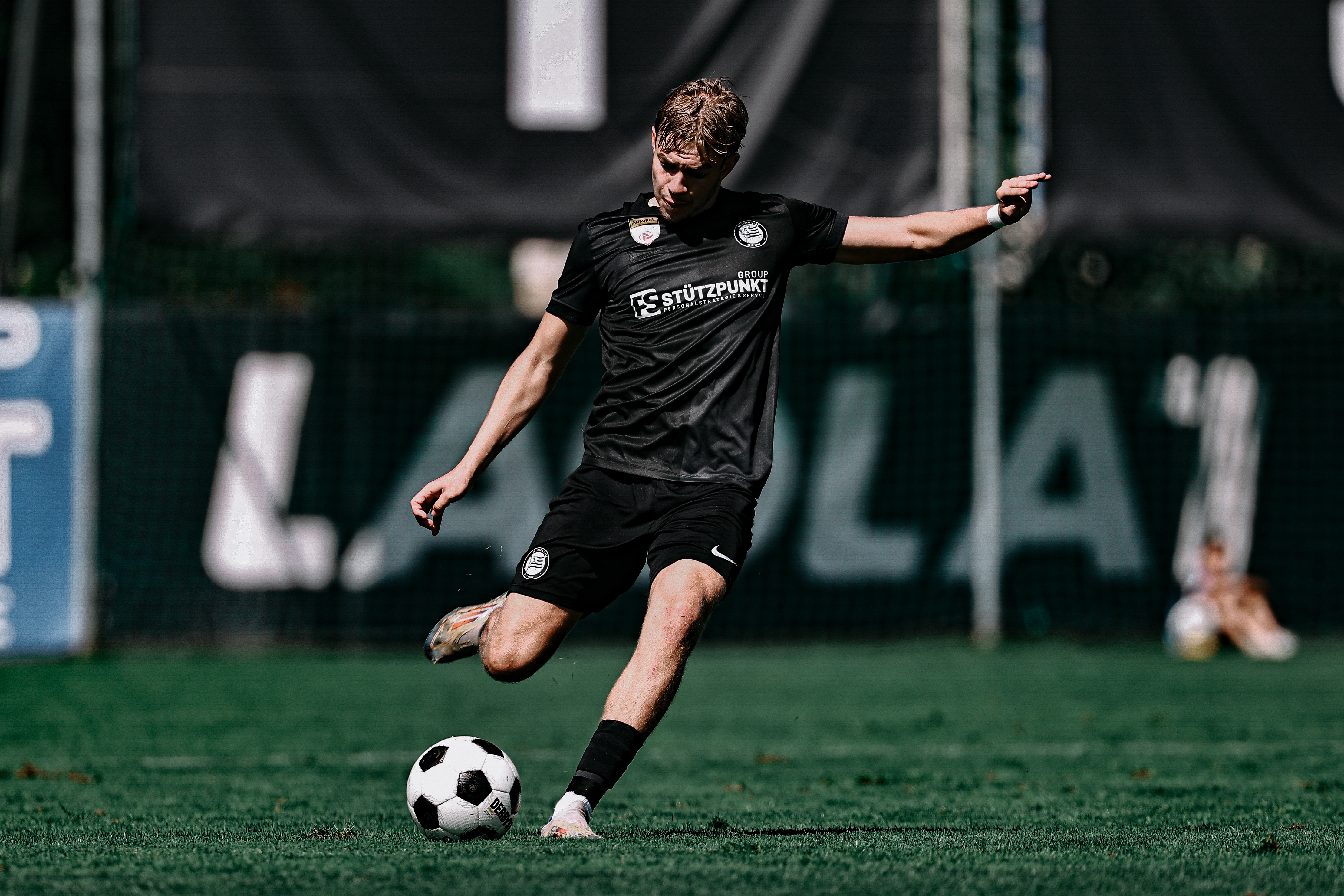 Ein Fußballer spielt den Ball.