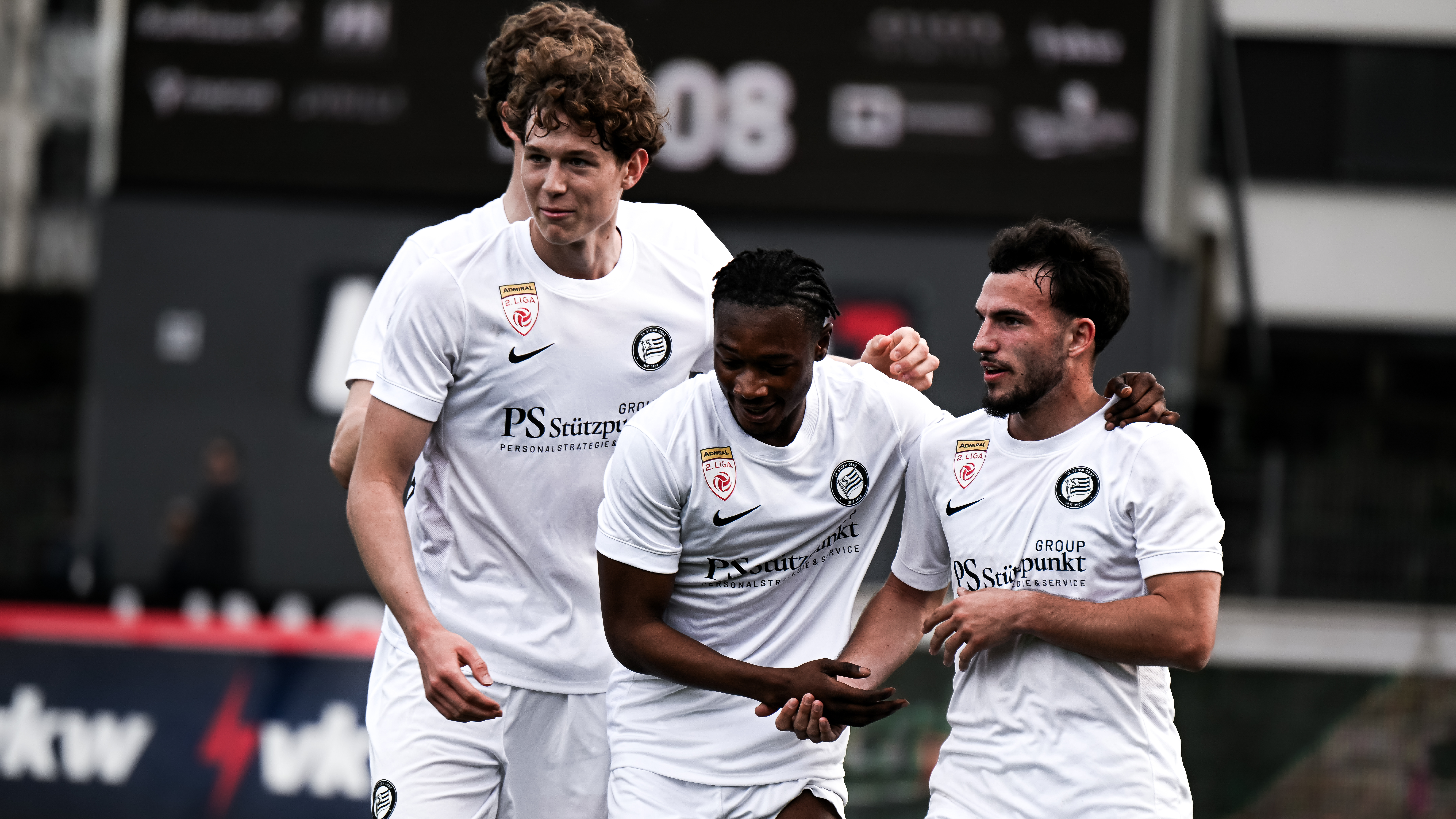 Vier Spieler in weißen Trikots jubeln